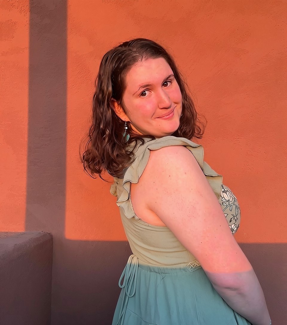 Portrait of Sarah against a terracotta wall